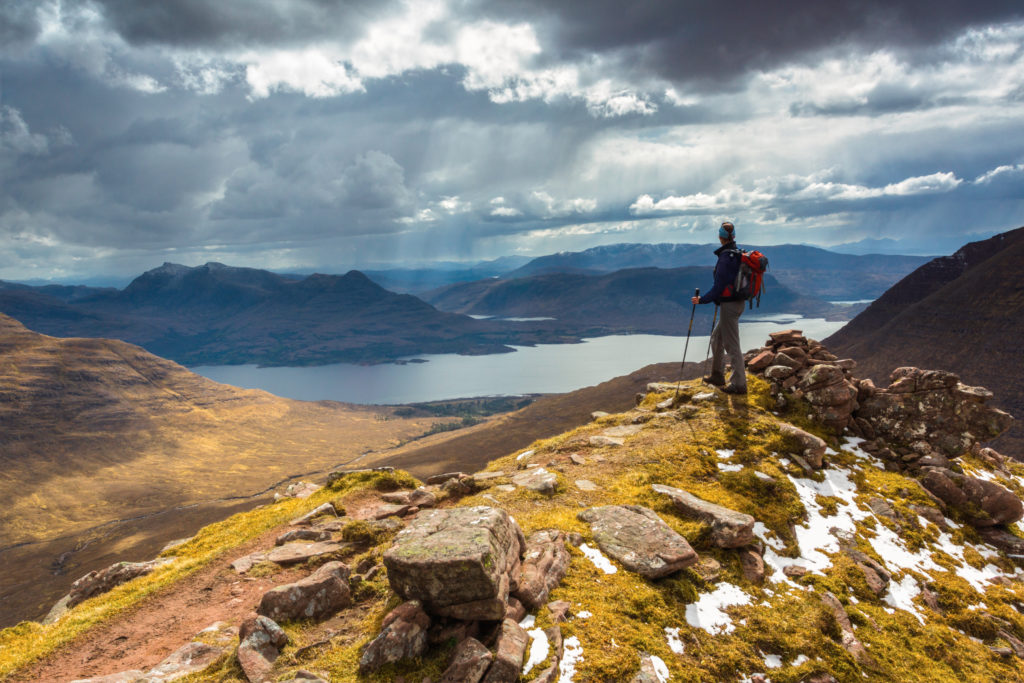 Benefits of nature Hike - better mood and less rumination Mountain scenery The silhouette of a hiker in a mountain wilderness scene in Scotland, UK.